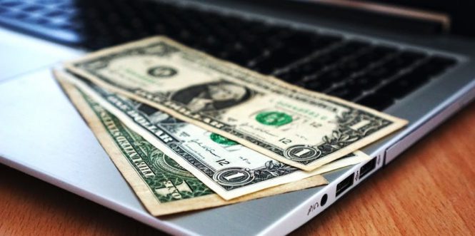 Image of money laid on a laptop