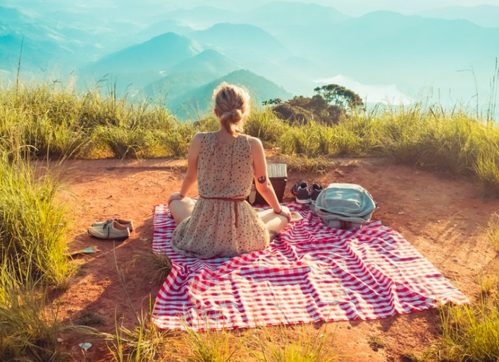 Image of a woman on blanket with picnic items 