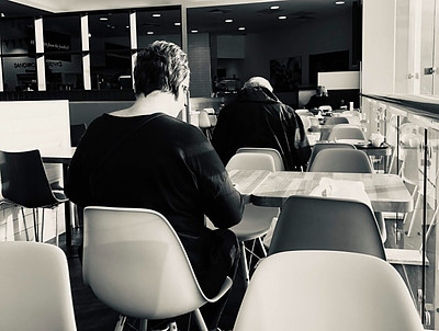 Image of two people in cafe at separate tables